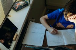 A child sits at a desk doing homework.