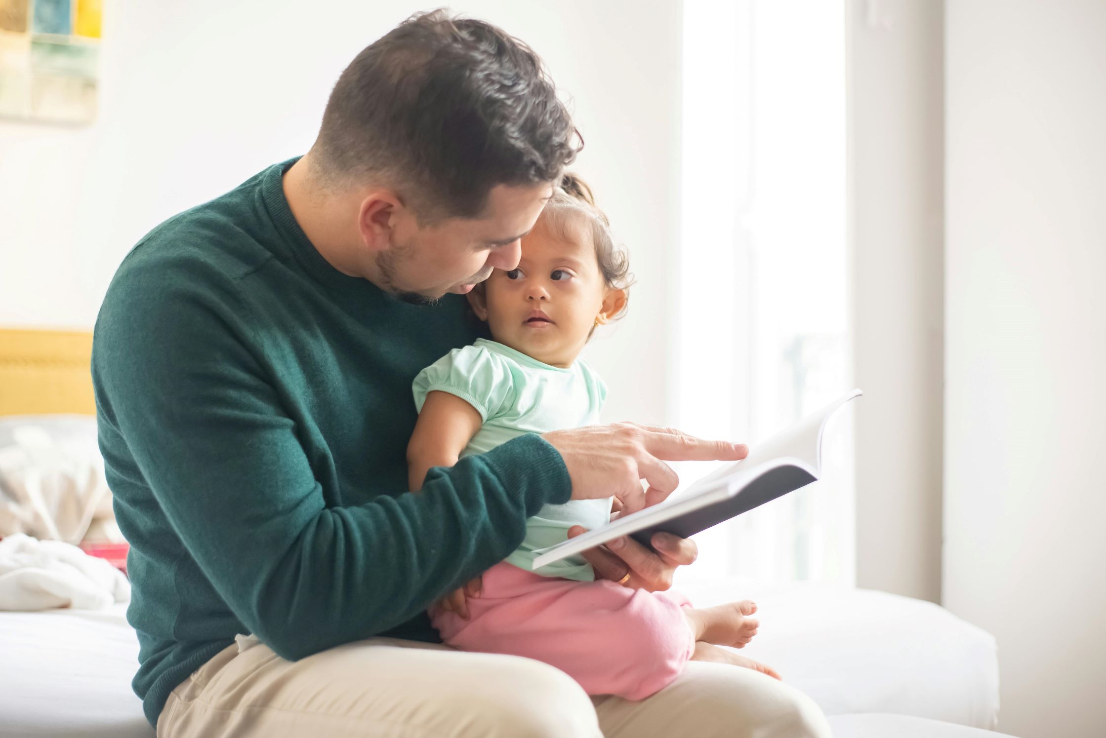 A father and young daughter reading.