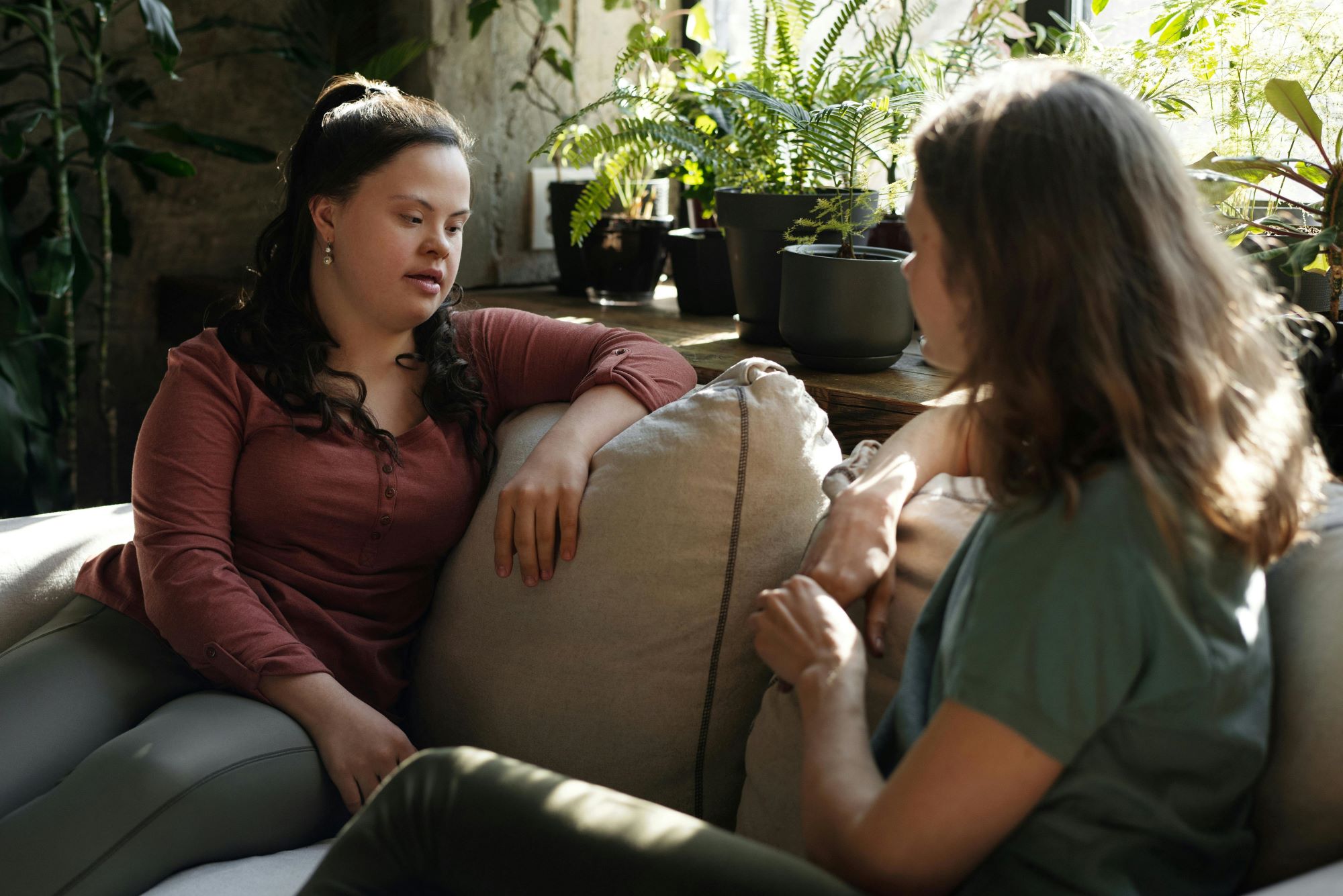Two roommates chatting on a couch.