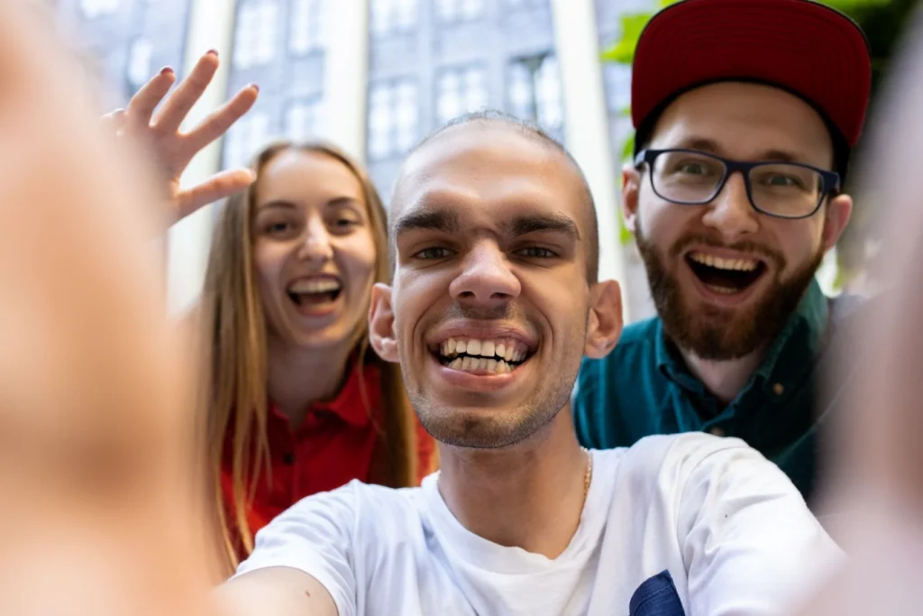 Three young people looking into the camera and smiling.